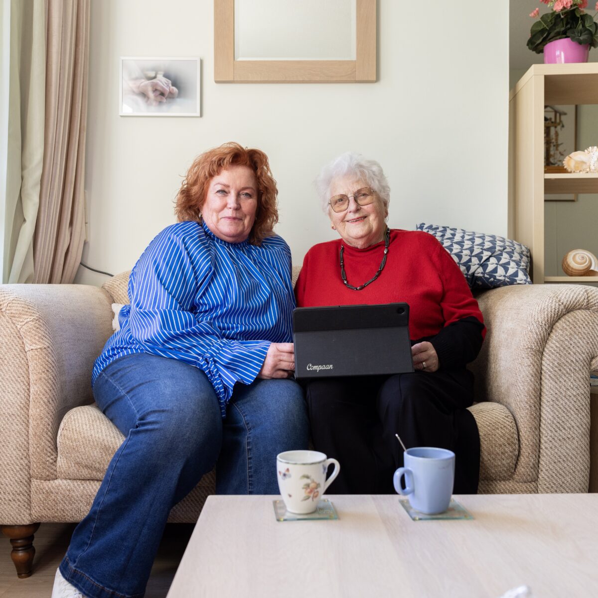 Collega met oudere vrouw en tablet