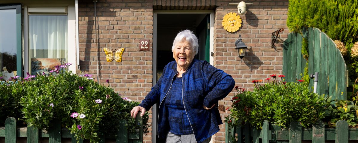 Oudere vrouw voor haar woning