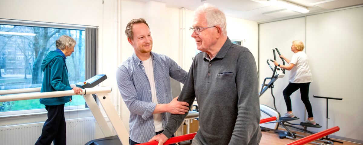 Collega met oudere man in beweegruimte