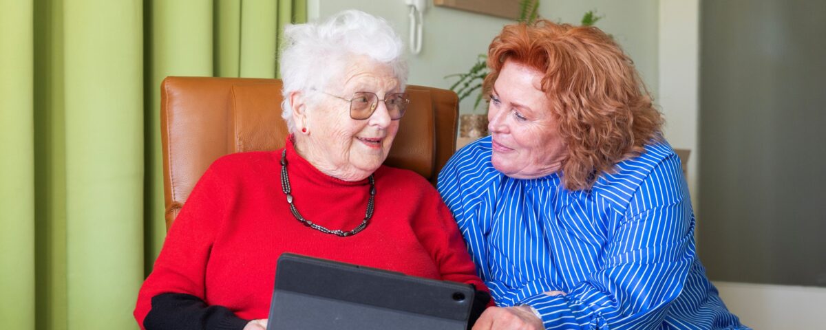 Collega met oudere vrouw en tablet