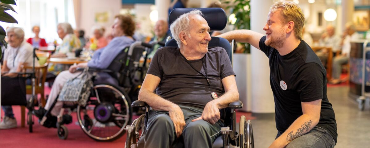 Collega binnen met oudere man in rolstoel