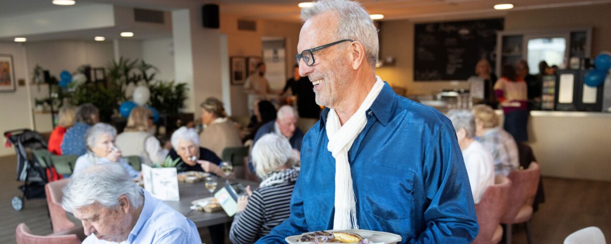 Man deelt bordjes uit met eten in restaurant
