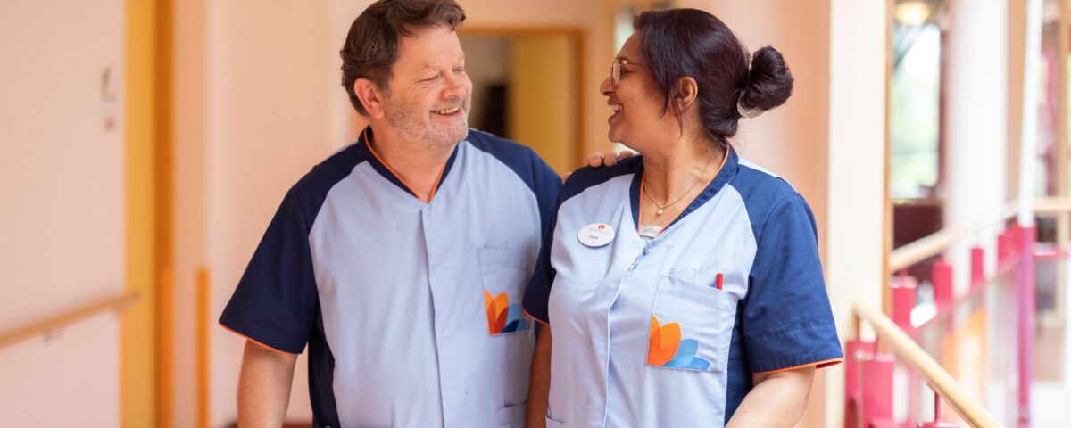 Twee collega's in de gang van een verpleeghuis