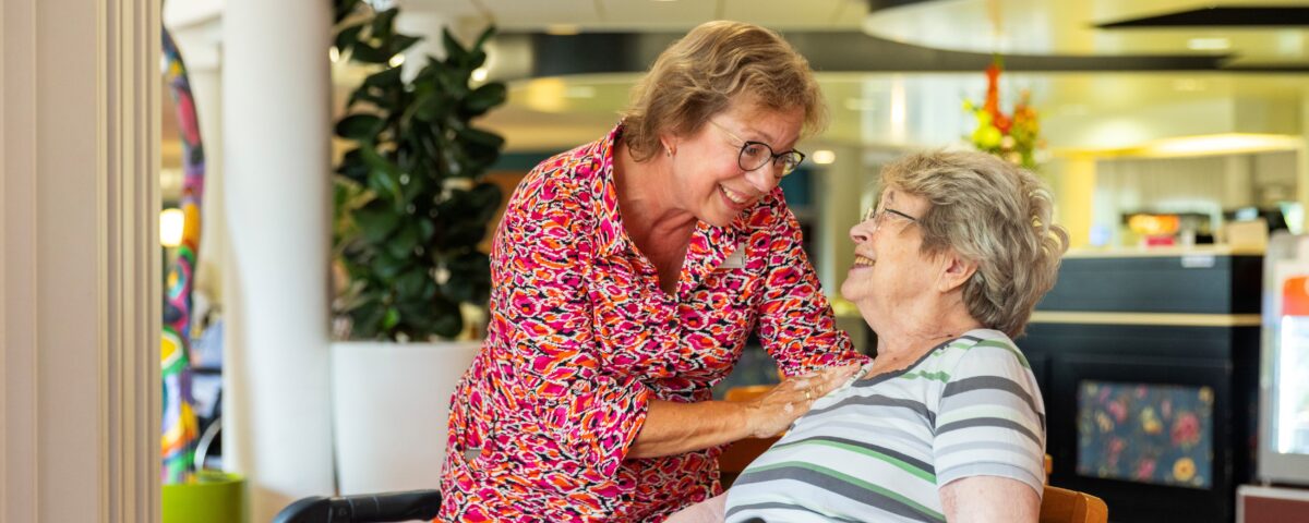 Collega met oudere vrouw en loopkar