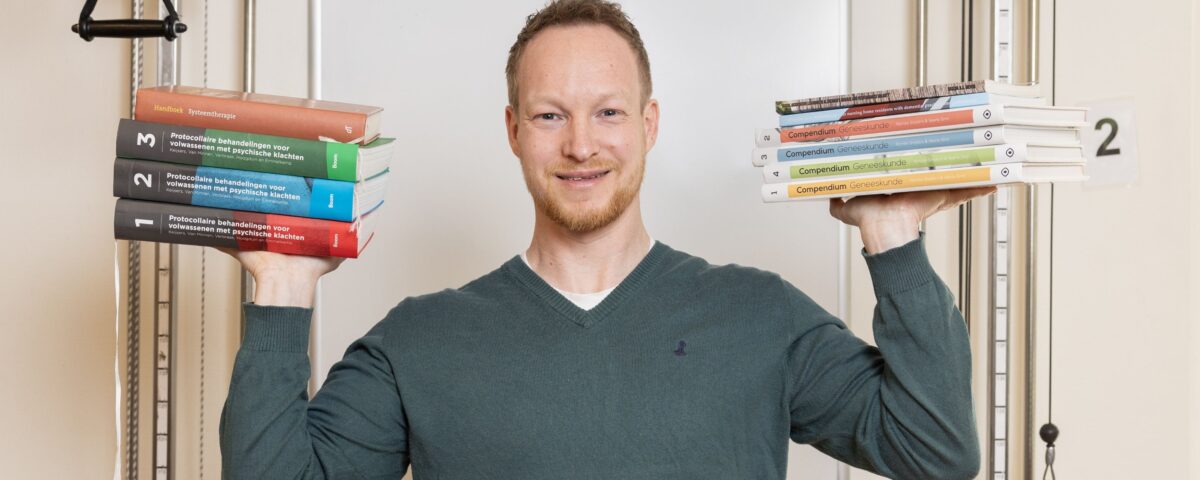 Collega met boeken in beide handen