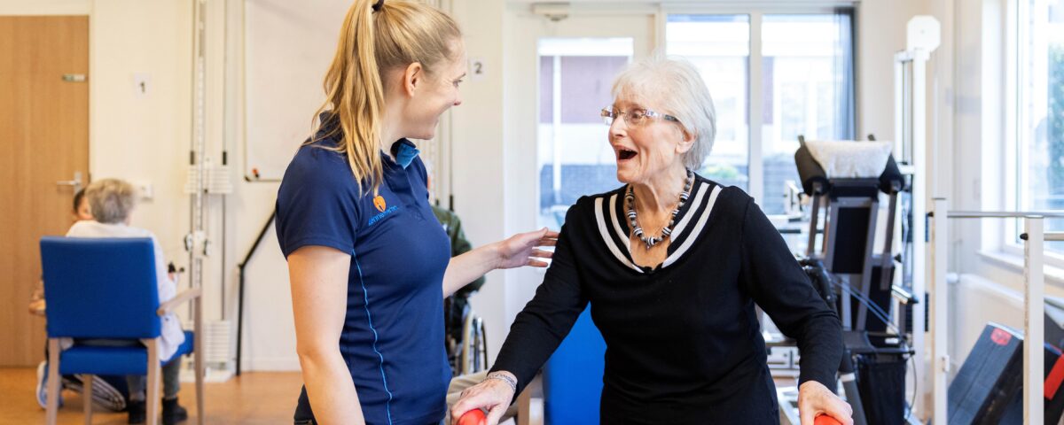 Collega met oudere vrouw in beweegruimte