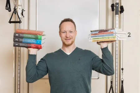 Collega met boeken in beide handen