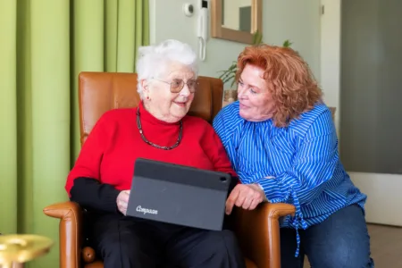 Collega met oudere vrouw en tablet