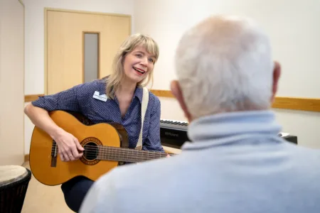Collega speelt gitaar voor oudere man