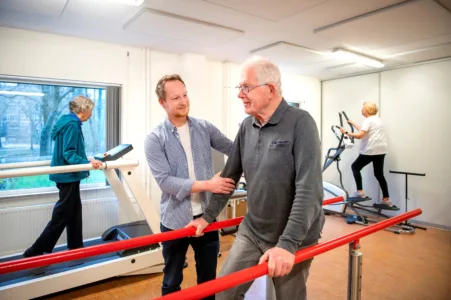 Collega met oudere man in beweegruimte
