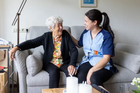 Collega met oudere vrouw op de bank