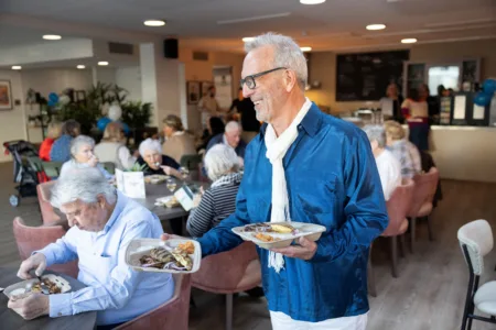 Man deelt bordjes uit met eten in restaurant