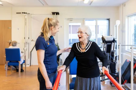 Collega met oudere vrouw in beweegruimte