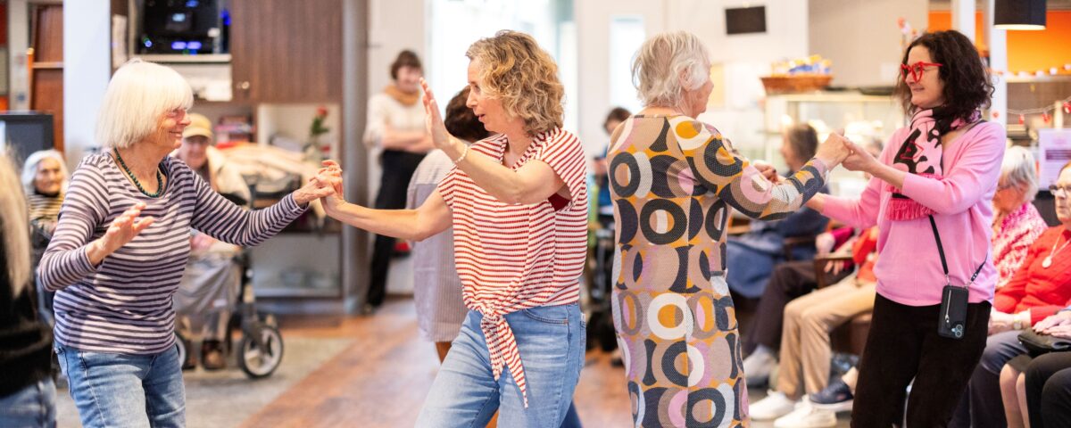 Bewoners en collega's dansen samen tijdens activiteit Ramplaanhart