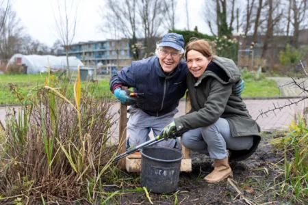 Cliënt dagbesteding is samen met een collega van Kennemerhart aan het tuinieren