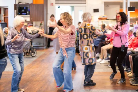 Bewoners en collega's dansen samen tijdens activiteit Ramplaanhart