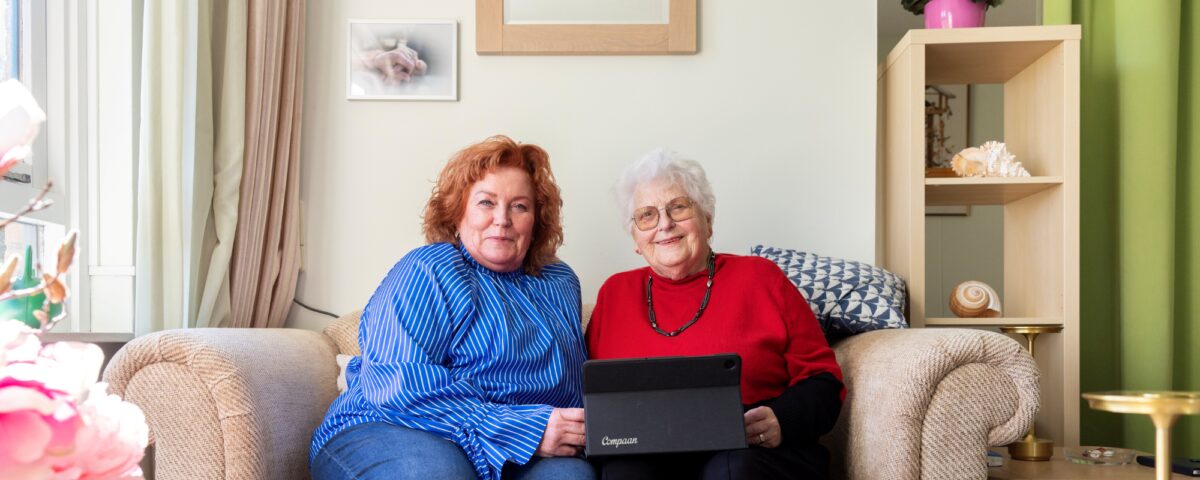 Cliënt en collega samen op de bank met tablet