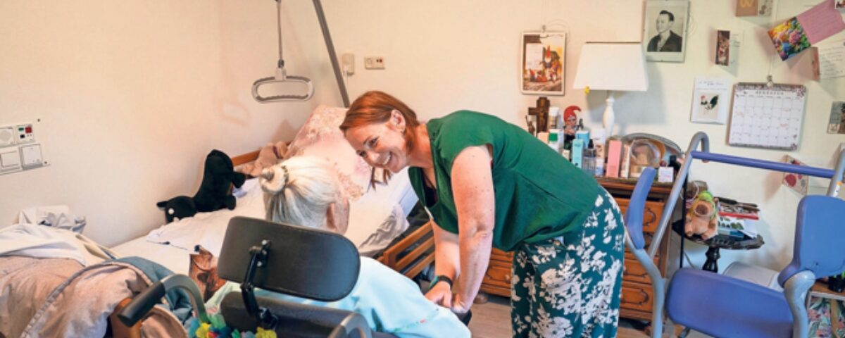 Vrouw in zorgomgeving met vrouw in rolstoel