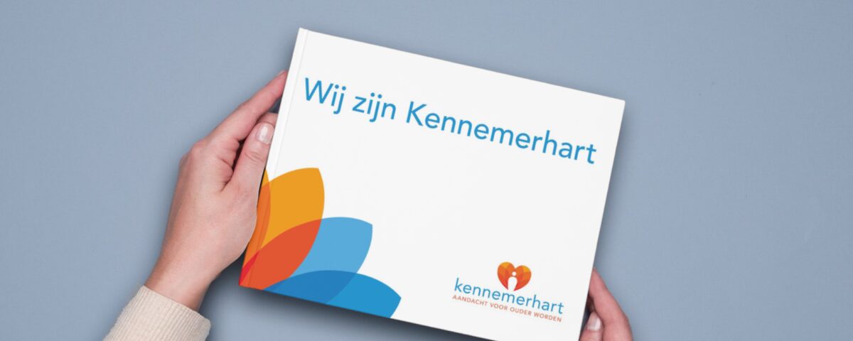 Twee handen houden een boek met tekst 'Wij zijn Kennemerhart' vast