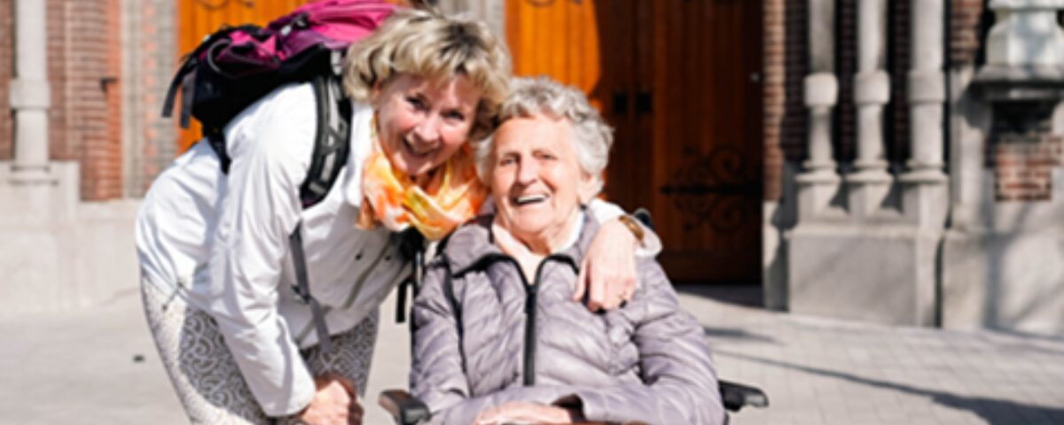 Vrouw samen met oudere vrouw in rolstoel buiten