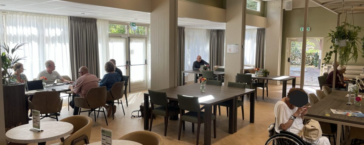 Mensen zitten aan tafels in gemeenschappelijke ruimte