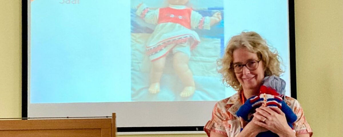 Persoon geeft een presentatie met zorgpoppen