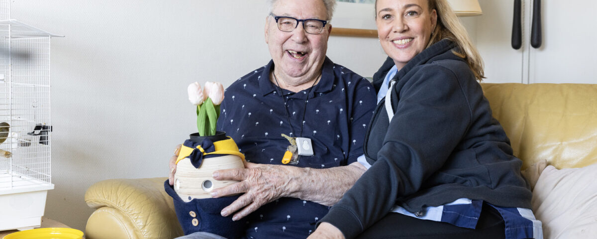 Vrouw met oudere man met zorgrobot Tessa