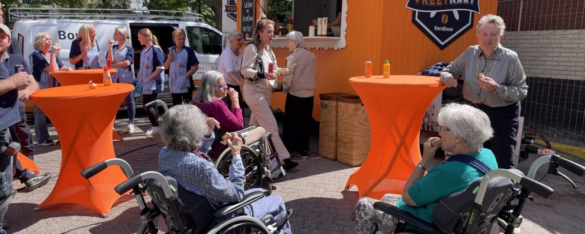 Collega's en bewoners buiten bij foodtruck