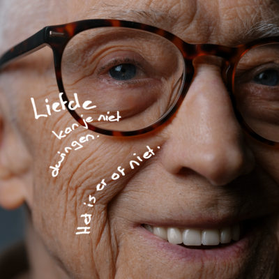 Close-up van oudere man met bril met tekst 'Liefde kun je niet dwingen. Het is er of het is er niet'.