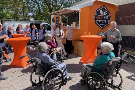 Collega's en bewoners buiten bij foodtruck