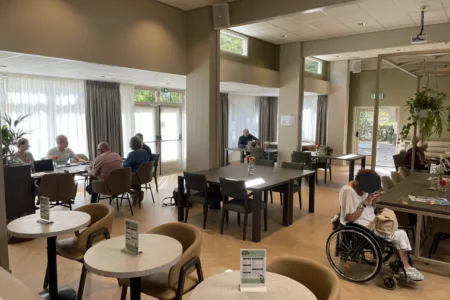 Mensen zitten aan tafels in gemeenschappelijke ruimte