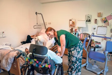 Vrouw in zorgomgeving met vrouw in rolstoel