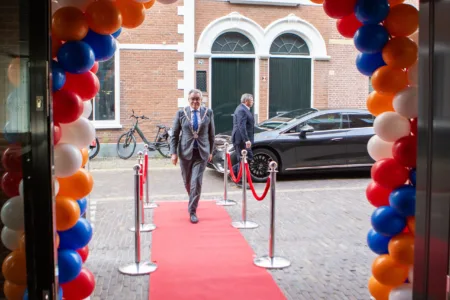 Man loopt gebouw in met ballonnenboog
