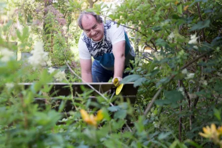 Man lachend aan het klussen buiten