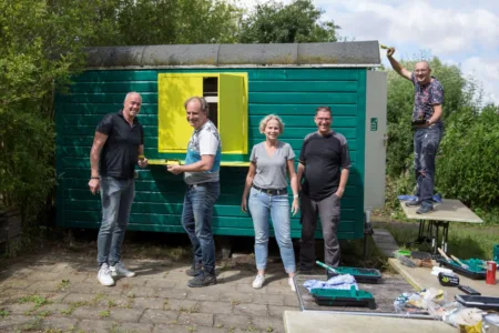 5 mensen een keet aan het verven